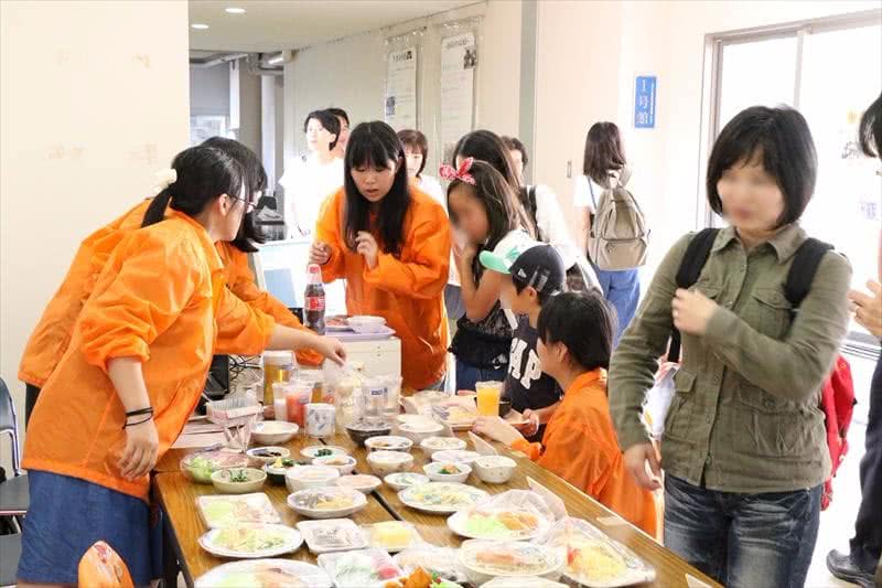 写真：並べられた料理とそれを見る人たち