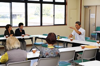 写真：コーヒーを飲みながら話をする横川教授と耳を傾ける参加者