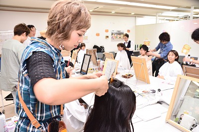 写真：aヘアアレンジをする女性美容師さん