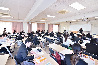 写真：学生を前に栄養士業務などをお話になる藤本先生