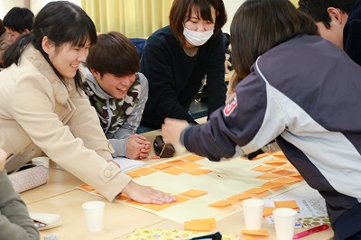 写真：テーブルに付箋を並べて貼っていく学生たち