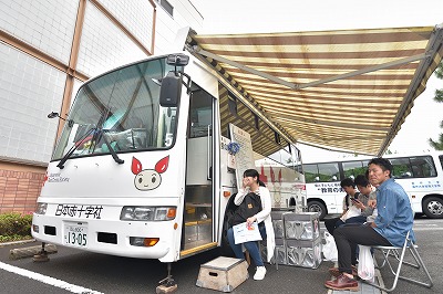 写真：献血バスと学生たち