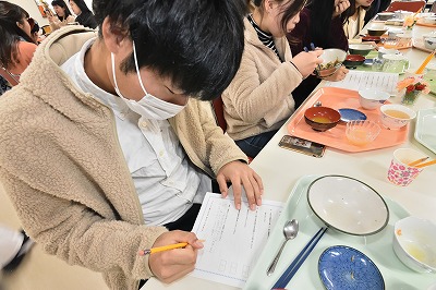 写真：食事後にアンケートに答える学生