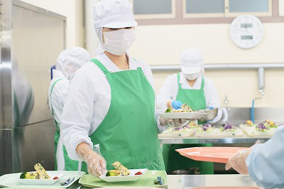 写真：調理担当の学生が丁寧に盛り付ける様子