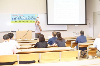写真：公開講座で書籍や資料の紹介をする有岡先生