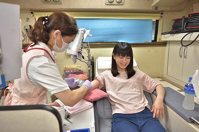 写真：緊張した面持ちで献血に協力する学生