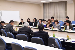 写真：会議室で並んで座る学生と教職員