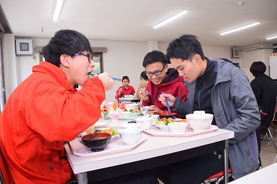 写真：提供された食事をおいしそうに食べる学生たち