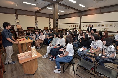 写真：館長橋爪さんの話を熱心に聞く学生たち