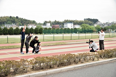 写真：カメラマンに撮影してもらう学生4人
