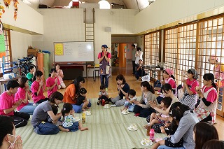 写真：児童館で一緒にいただきますをする学生と親子