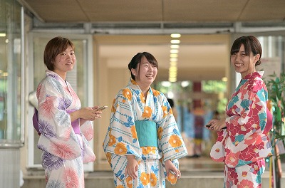 写真：a通路で談笑する浴衣姿の女子学生3名