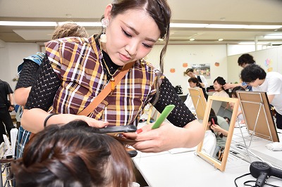 写真：aヘアアレンジをする女性美容師さん