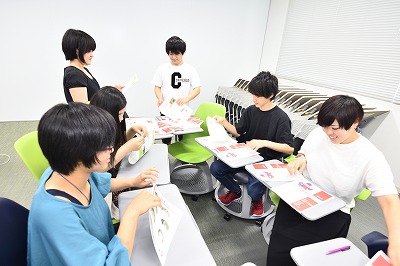 写真：出来上がったばかりの情報紙を折って製本するグループ