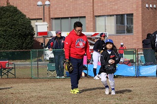 写真：投球練習する参加者と、それを見守るコーチ