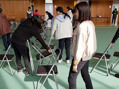 写真：準備の様子。椅子並べをする学生たち