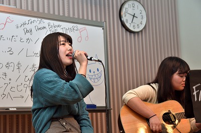 写真：熱唱する学生1人とギターを弾く学生1人