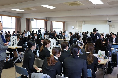 写真：合同就職説明会の会場。大勢の学生が各企業のブースに分かれて説明を聞いている
