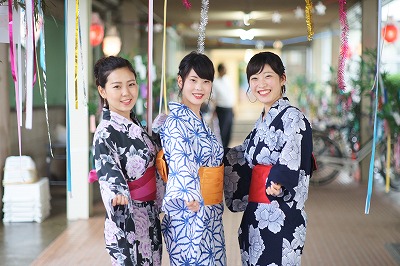 写真：a女子学生3名が七夕飾りの下でポーズ