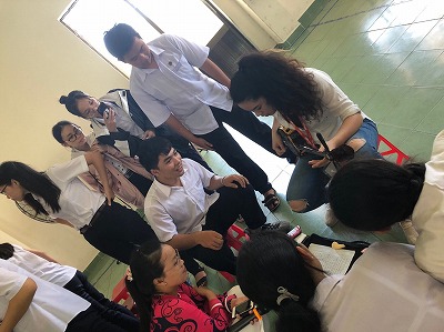 ベトナムの学生の前で沖縄の伝統楽器さんしんをひく様子