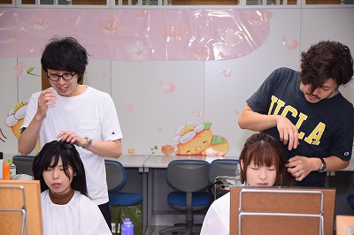 写真：美作大学七夕ヘアアレンジ。ヘアアレンジをする美容師と学生
