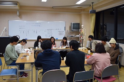 写真：カタカナのロの字に机を並べ、議論する学生と参加者