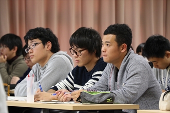 写真：真剣に授業を聞く3名の男子学生