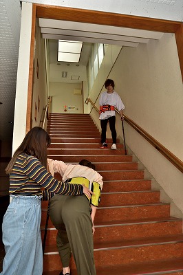 写真：片マヒ体験で学内の階段をのぼる学生