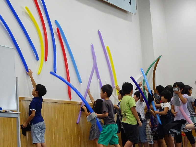 写真：色とりどりの風船を壁にくっつける子どもたち