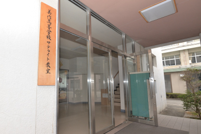 写真：サテライト教室のある7号館の玄関。「岡山県美作高等学校サテライト教室」の看板がかかる