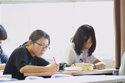 写真：メモをとりながら講演を聞く女子学生2人