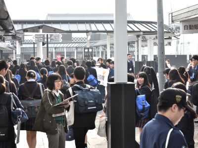 写真：津山駅前、たくさんの通学通勤者、チラシを配る学生1人