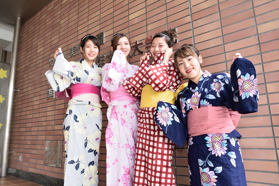写真：浴衣を見せ合いながらポーズをする4名の女子学生