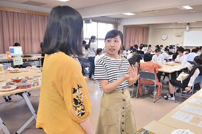 写真：参加者に熱心に授業について説明する学生スタッフ