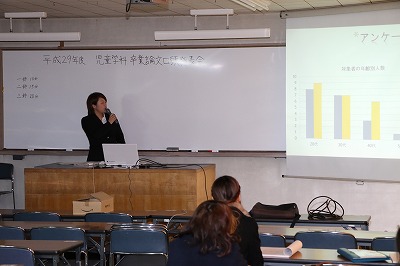 写真：スクリーンにスライドを投影して発表する学生