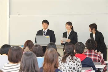 写真：3名の学生が参加者の前に立って発表を行う様子