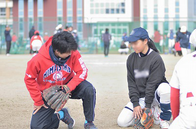 写真：外野手講習で熱心に指導するくらた選手と熱心に聞く受講者