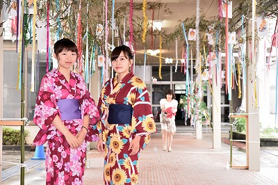 写真：a七夕飾りの下で2人の女子学生。横並び