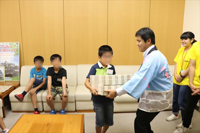 写真：２億円を持つ小学生とそれを支える信用金庫の職員