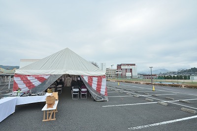 写真：起工式が執り行われたテント。建設予定地から校舎を望む