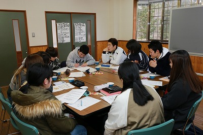 写真：テーブルを囲んで座り、グループワークを行う学生たち