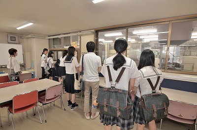 写真：施設見学で実習食堂の案内を聞く参加者