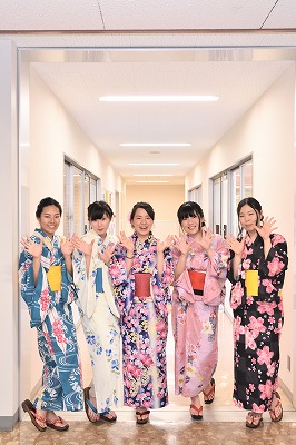 写真：廊下に並んでポーズを決める女子学生5名