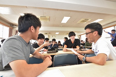 写真：グループで討議する学生たち4人