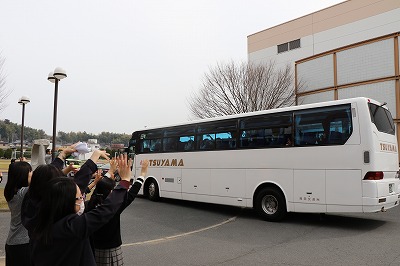 写真：バスに向かって手を振る教員たち