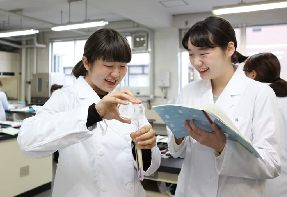 写真:授業を受ける白衣のDさんと友達