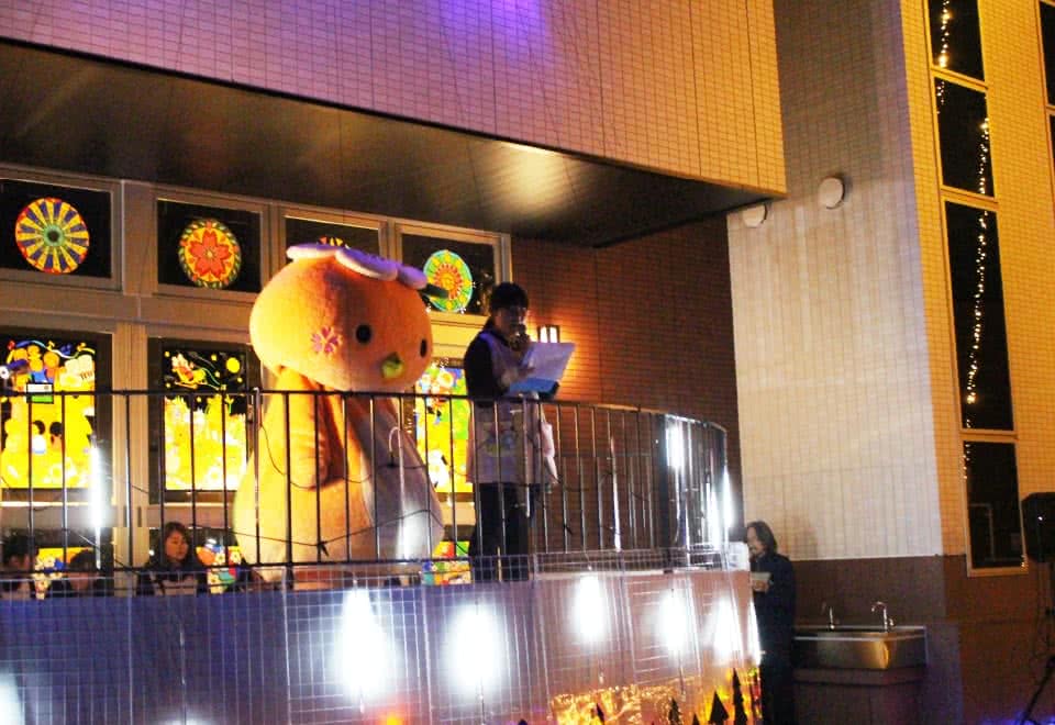 写真:サークルコモンズの半円ステージにいるみまっぱちゃんとマイクを持った女子学生。