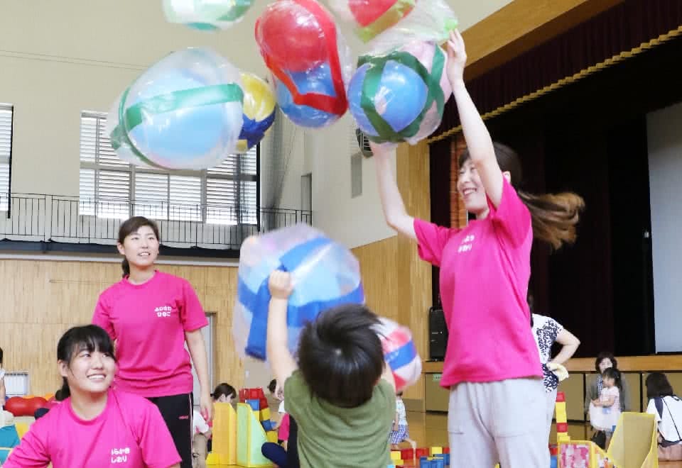 写真:手作りの遊具で遊ぶ子どもと学生