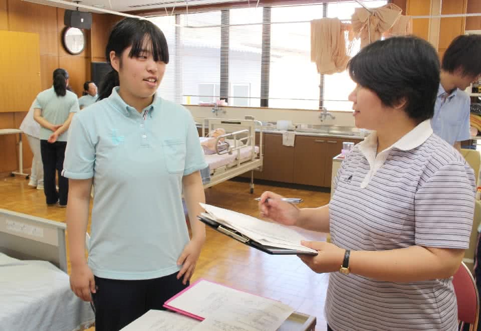写真:現場での介護の仕方について指導をけている様子