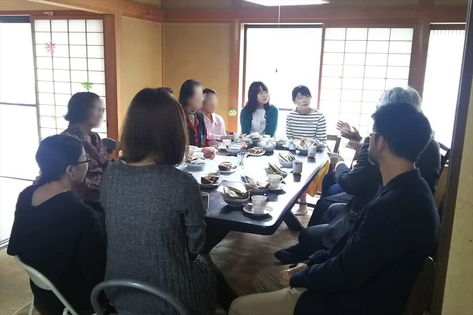 写真:支縁の居間でお菓子を食べながら語り合う学生と地域の方